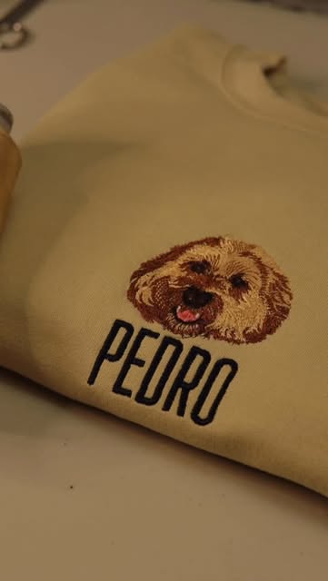 A dog portrait embroidered above the name Pedro on a sand-coloured sweatshirt.