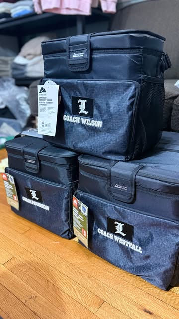 A collection of black bags personalised with a white embroidered monogram.